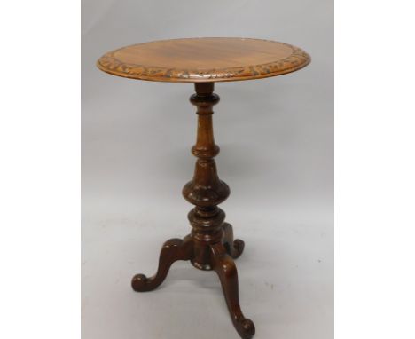 A Victorian walnut occasional table, the circular top with a carved border, on a turned column and tripod base, 54cm diameter