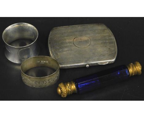 A collection of small silver, to include two napkin rings, a cigarette case, and a blue glass double ended scent bottle with 