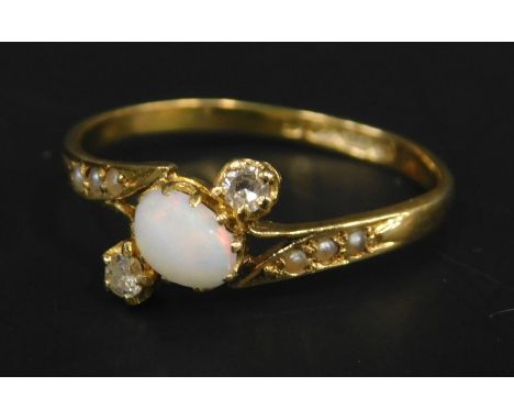 An 18ct gold opal and diamond twist ring, with central opal flanked by two smaller stones and three inset seed pearls to each