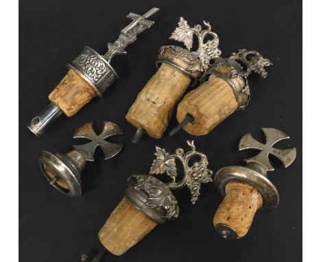 Various white metal and silver bottle stops, to include an example model with a windmill, others with grapes, vines, crosses,