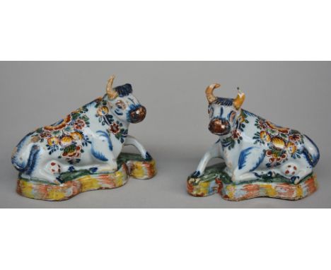 A pair of 18thC polychrome decorated Dutch Delftware cows, H 10 - W 12 - 13 cm (damage and restoration on the ears and horns;