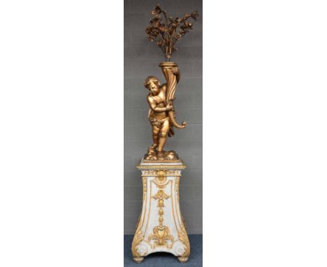 An imposing gilt wooden torchère figuring a putto holding a cornucopia (transformed into a lamp); on a polychrome and gilt de