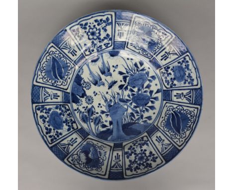 An exceptional Japanese Arita charger, cobalt-blue underglaze, decorated with a butterfly chased by birds on a rock and other