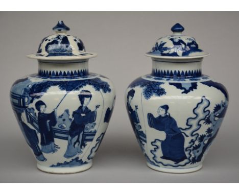 A pair of Chinese blue and white vases with cover, decorated with a genre scene, probably Kangxi, H 36,5 cm (one cover is not