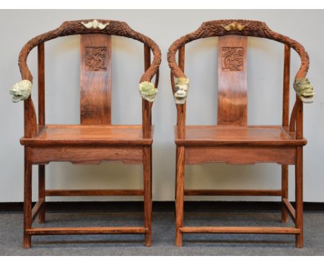 A pair of Chinese armchairs in exotic wood, the horseshoe-shaped back richly carved and crowned with jade, H 106,5 - W 66 cm 