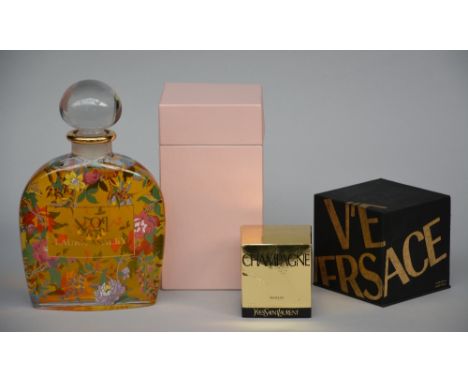 A set of four factice perfume bottles: Yves Saint Laurent, Christian Dior, Versace, Laura Ashley, with three of them in their
