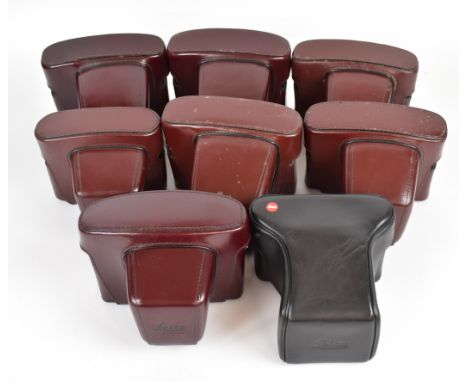 Eight Leica camera cases comprising seven burgundy and one black example