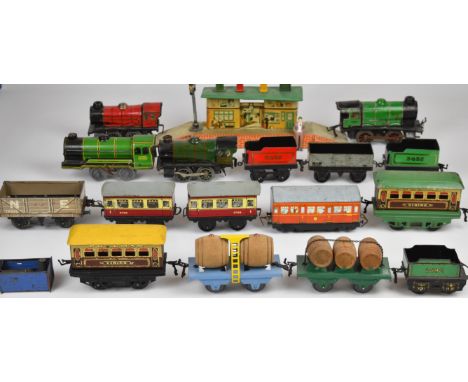 A collection of Hornby tinplate clockwork 00 gauge model railway to include four engines, passenger carriages, goods wagons a
