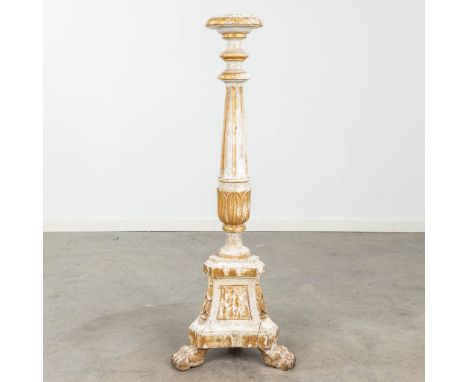 A large candlestick made of sculptured and patinated wood, standing on claw feet. 19th century.  Dimensions: (W:38 x H:100 cm