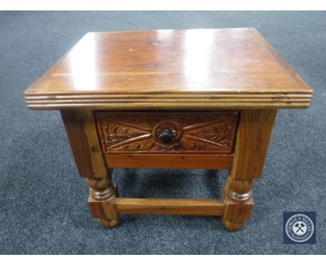 A carved hardwood lamp table fitted a drawer 