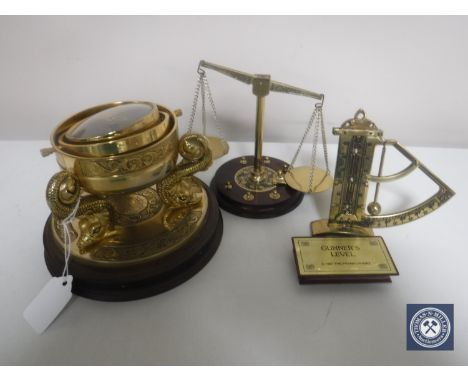 A reproduction brass ship's style compass on wooden stand together with a Franklin Mint brass gunner's level and a set of Fra
