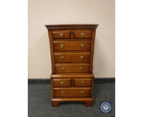 A Reprodux miniature mahogany eight drawer chest on bracket feet, height 76cm