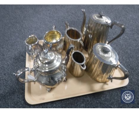 A tray containing a four-piece Sheffield EPNS tea service together with a three-piece plated tea service