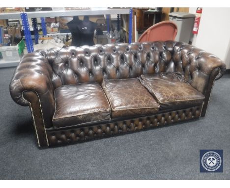 A brown button leather three seater Chesterfield settee 