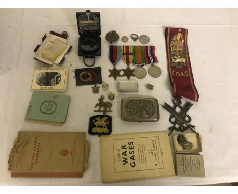 Box of WWII military items to include WWII Medals,Compass,  Insignia, Cap badges, Gas Manuals, Postcards and a White Metal Ne