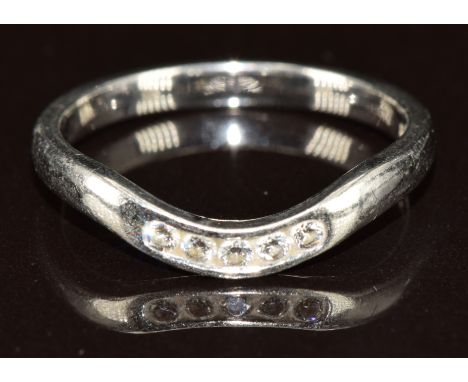 A platinum ring set with five diamonds, designed to fit around an engagement ring, 3.6g, size M
