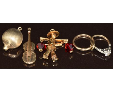 Four 9ct gold charms/ pendants in the form of a hedgehog, violin, engagement ring and wedding band and the other a water carr