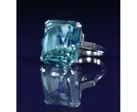Art Deco platinum ring set with an emerald cut zircon of approximately 22ct&nbsp;and a baguette cut diamond to each shoulder,