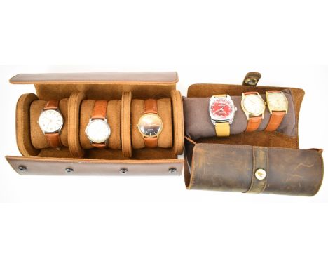 Six various gentleman's wristwatches comprising Lemania, Eterna, Sandoz, Baume, Smiths and one other, in brown leather displa