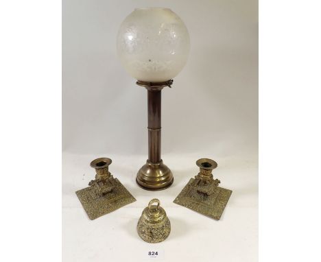 A Victorian brass candle stand with glass globe shade, a pair of brass candlesticks and a bell 