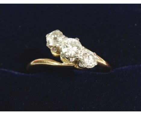 An 18 carat gold three stone diamond crossover ring (unmarked), size L to M, 2.8g 