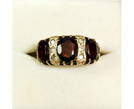 A 9ct gold ring set three garnets and six small diamonds, size K-L 