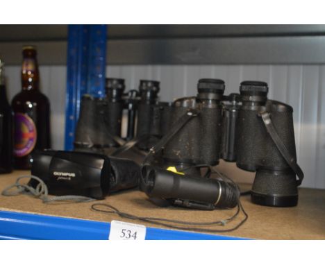 Three pairs of binoculars and an Olympus camera