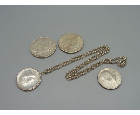 Two U.S. dollars, 1922 and 1923, and two U.S. half dollars, one with mount and silver chain 