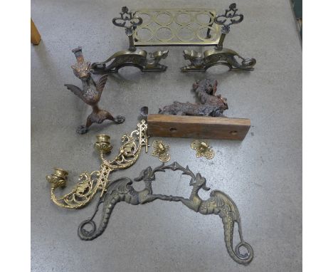 A cast dragon door stop on a wooden base, a pair of griffin candle wall brackets, a trivet, one griffin fire dog and a bracke