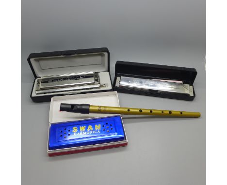 Three harmonicas including Swan Performance harmonica 24 and chromatic 12-48 harmonica and a tin whistle 