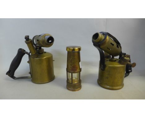 Two brass blow torches, British Monitor and one other and a novelty Eccles miner's lamp table lighter 