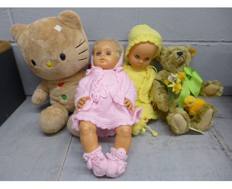 Two Baby First Love dolls and two soft toys including a Steiff Teddy bear with growler and holding daffodils 