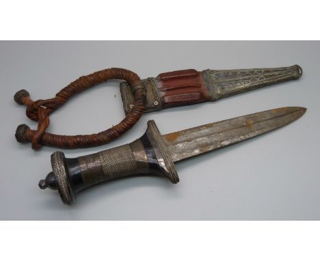 A North African white metal dagger with leather and white metal scabbard 