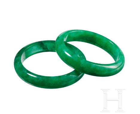 Ein Paar Jade-/Jaspis-Armreife, China, 20. Jhdt.   Grüne Armreife mit weißen und schwarzen Einschlüssen, leicht lichtdurchläs