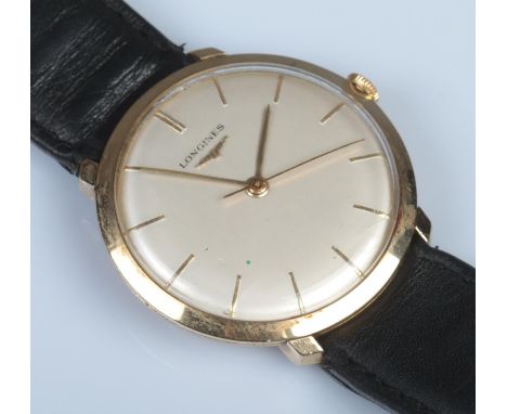 A Gents 9ct Gold Longines manual wristwatch, with baton markers on black strap.  Running. Scratches and slight crack to the g