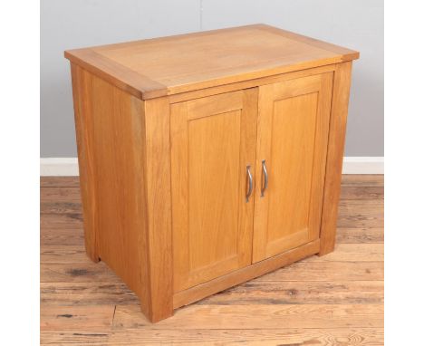 A modern oak cabinet with double doors and sliding interior shelf. Hx85cm Wx90cm Dx58  