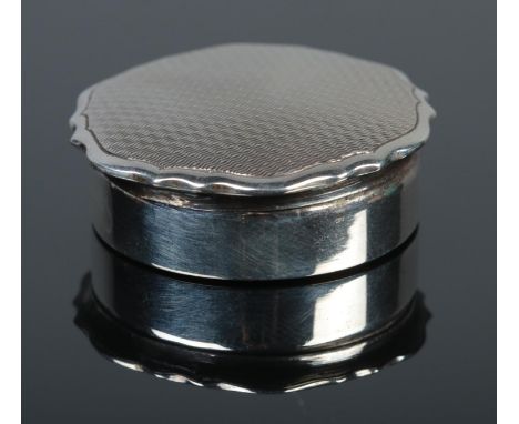 A silver pill box, with engine turned top. Assayed for Birmingham, 1933, by William Neale &amp; Son Ltd. Total weight: 9.9g  