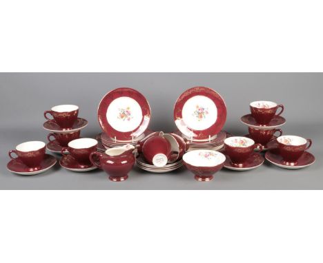 A maroon Empire of England part tea service, consisting of cups and saucers, milk jug, sugar bowl and side plates. Approximat
