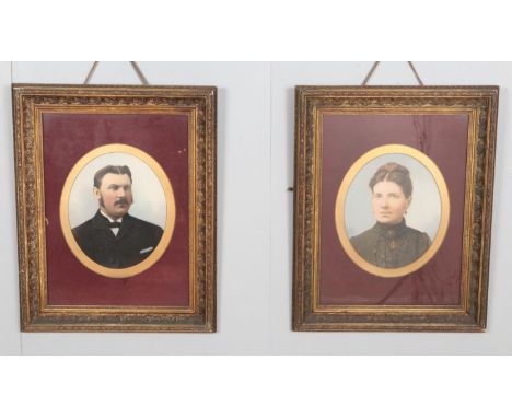 A pair of framed early twentieth century oleograph portraits with applied oil paint detail depicting a lady and gentleman. In