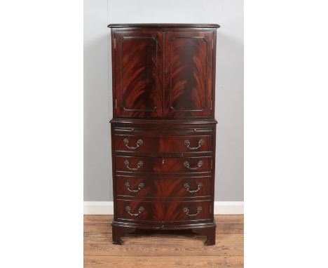 A bow fronted mahogany drinks cabinet, with cupboard doors, pull-out shelf and fake drawers to the base. Height: 131cm.  