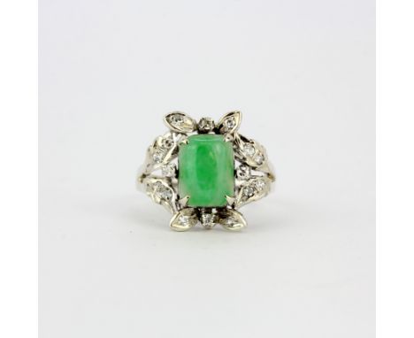 An 18ct white gold (marked 18K) ring set with cabochon jade surrounded by diamonds, (M.5).