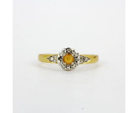 An 18ct yellow and white gold ring set with a citrine and diamonds, (O.5).