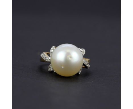 A 10ct yellow gold (marked 10K) ring set with a large cultured pearl and diamond shoulders, (O).