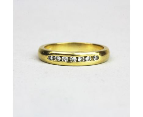 An 18ct yellow gold (tested) diamond set half eternity ring, (N).