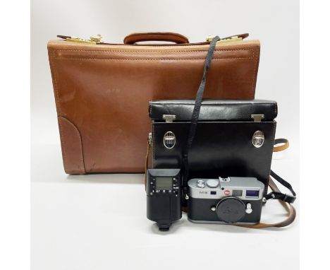 A Leica m9 camera with 3 different lenses and accessories and instruction manual in a high quality brown leather case