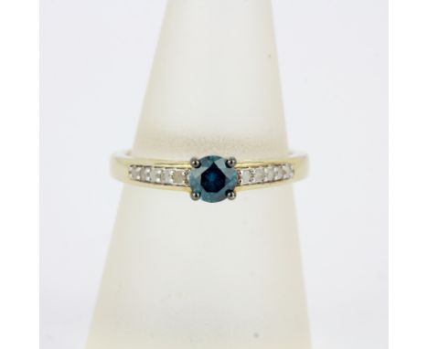 A 10ct yellow gold ring set with a round cut blue diamond and white diamond set shoulders, (O).