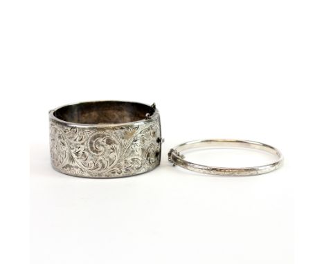 A wide engraved vintage hallmarked silver hinged bangle together with a further bangle.