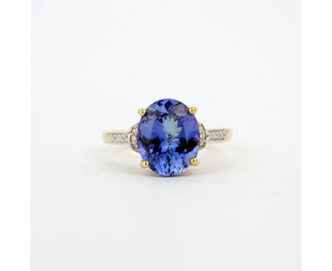 A 14ct yellow gold ring set with a large oval cut tanzanite and diamond set shoulders, (O).