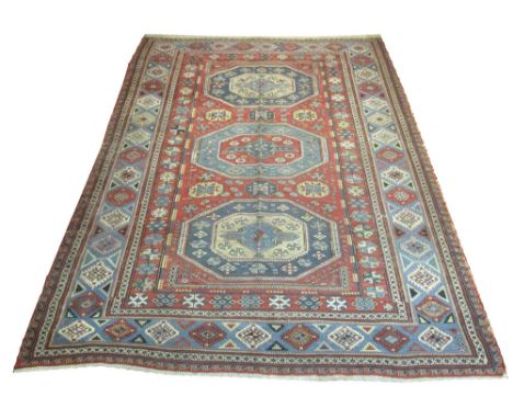 FINE ANTIQUE CAUCASIAN SOUMAK CARPET, 298cm x 213cm, 19th century, triple medallions on a terracotta field within correspondi