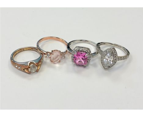 Three white metal dress rings and another plated dress ring indistinctly stamped